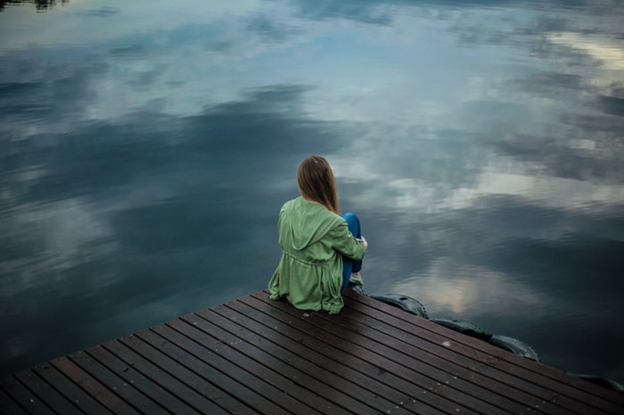 stress levels woman sitting calmly by the water