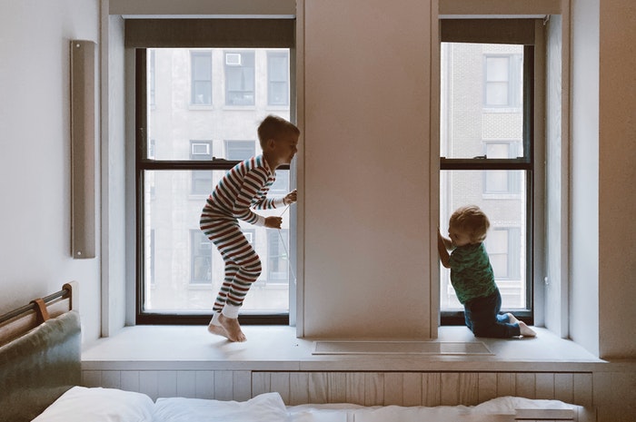 two kids playing beside windows happy home