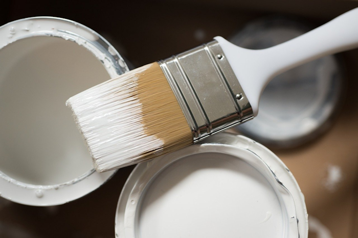 Paintbrush and Open tins of paint DIY
