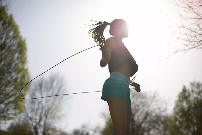 weight loss woman jumping rope at sunset