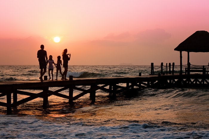 Vacation sunset beach family on a boardwalk